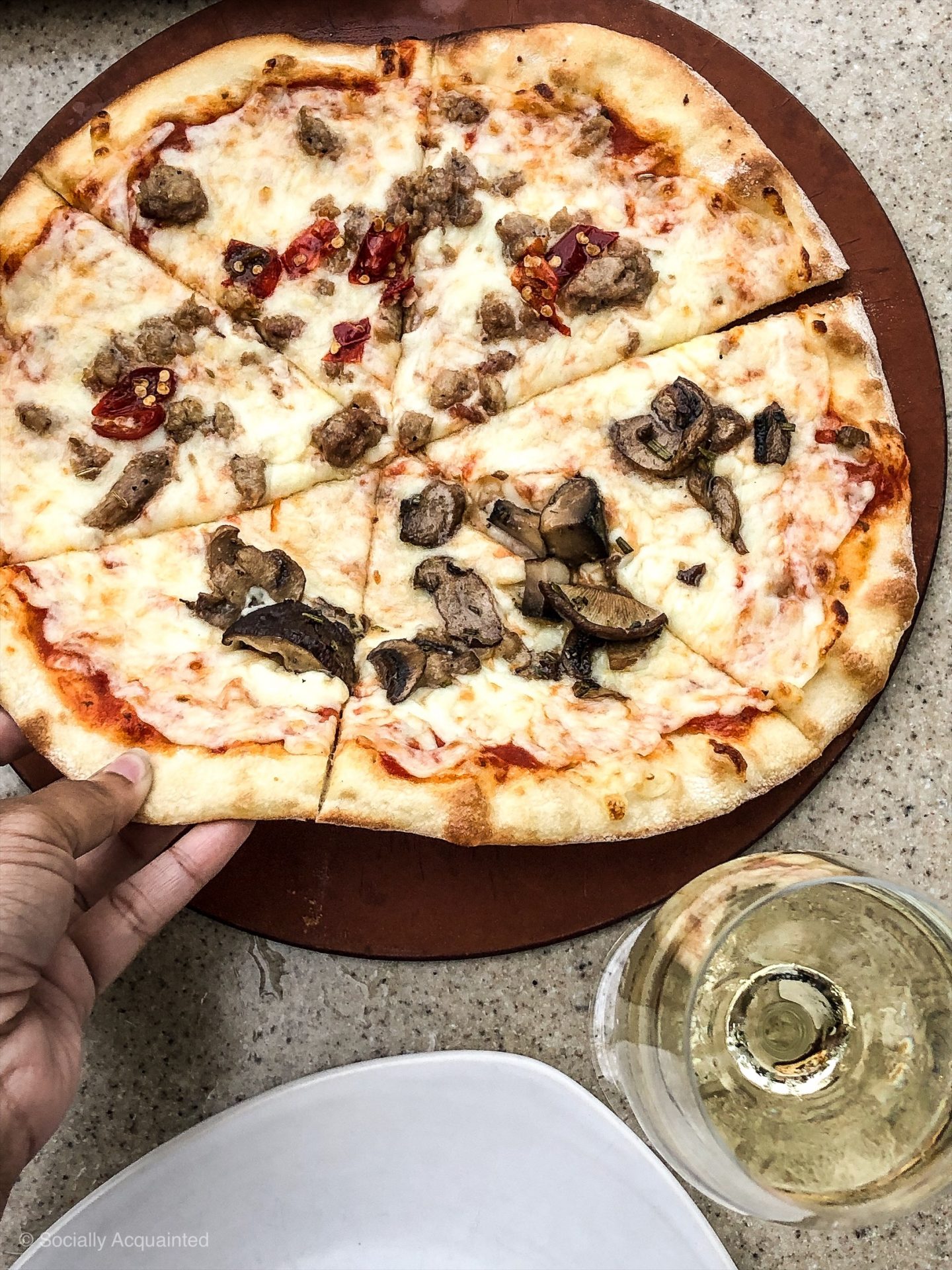 Half funghi, half sausage pizza and a glass of Moscato